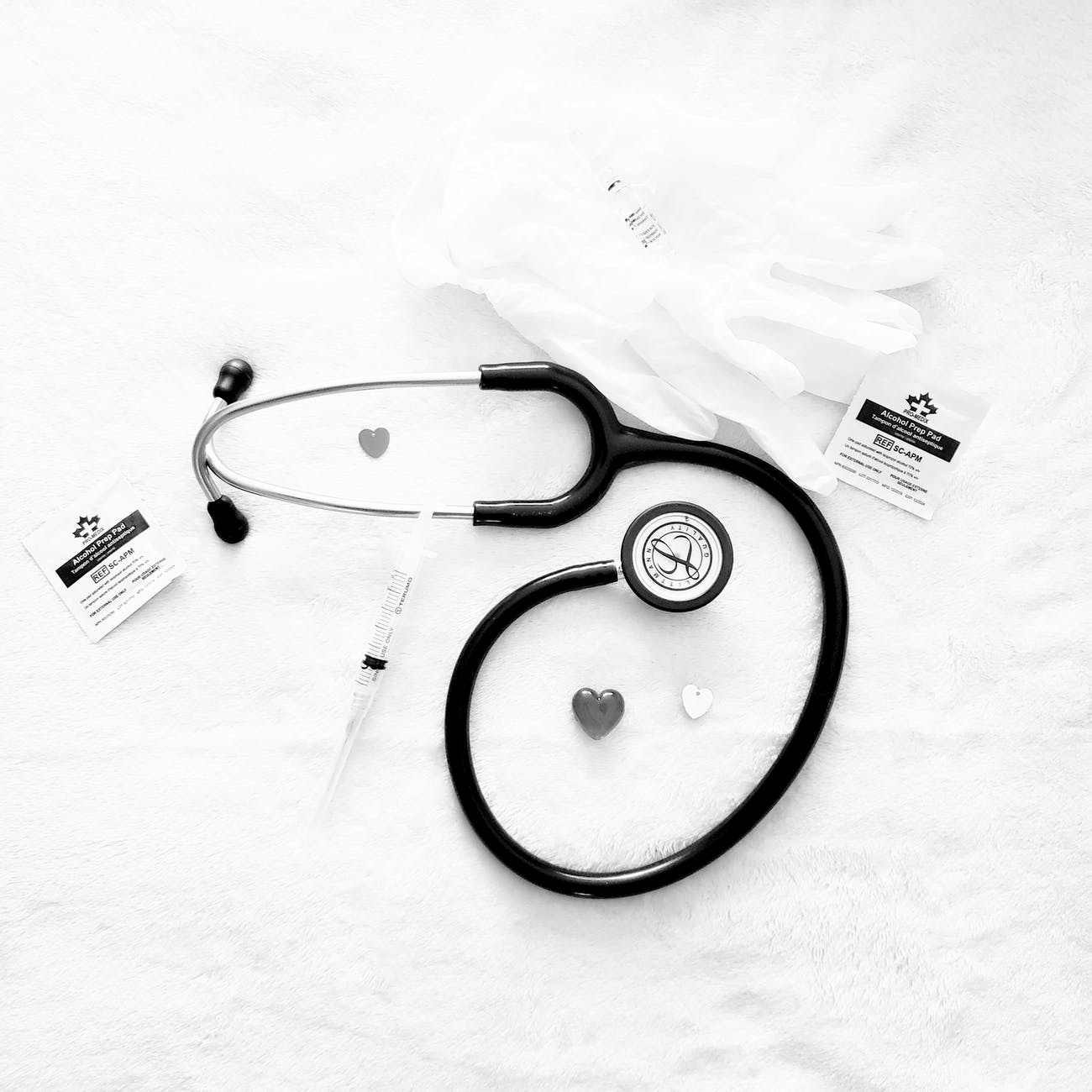 black and silver stethoscope on white textile