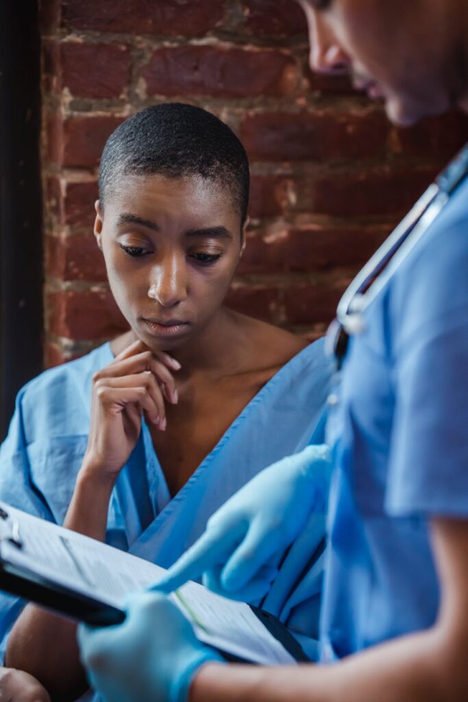 pensive black patient discussing diagnosis with doctor in hospital