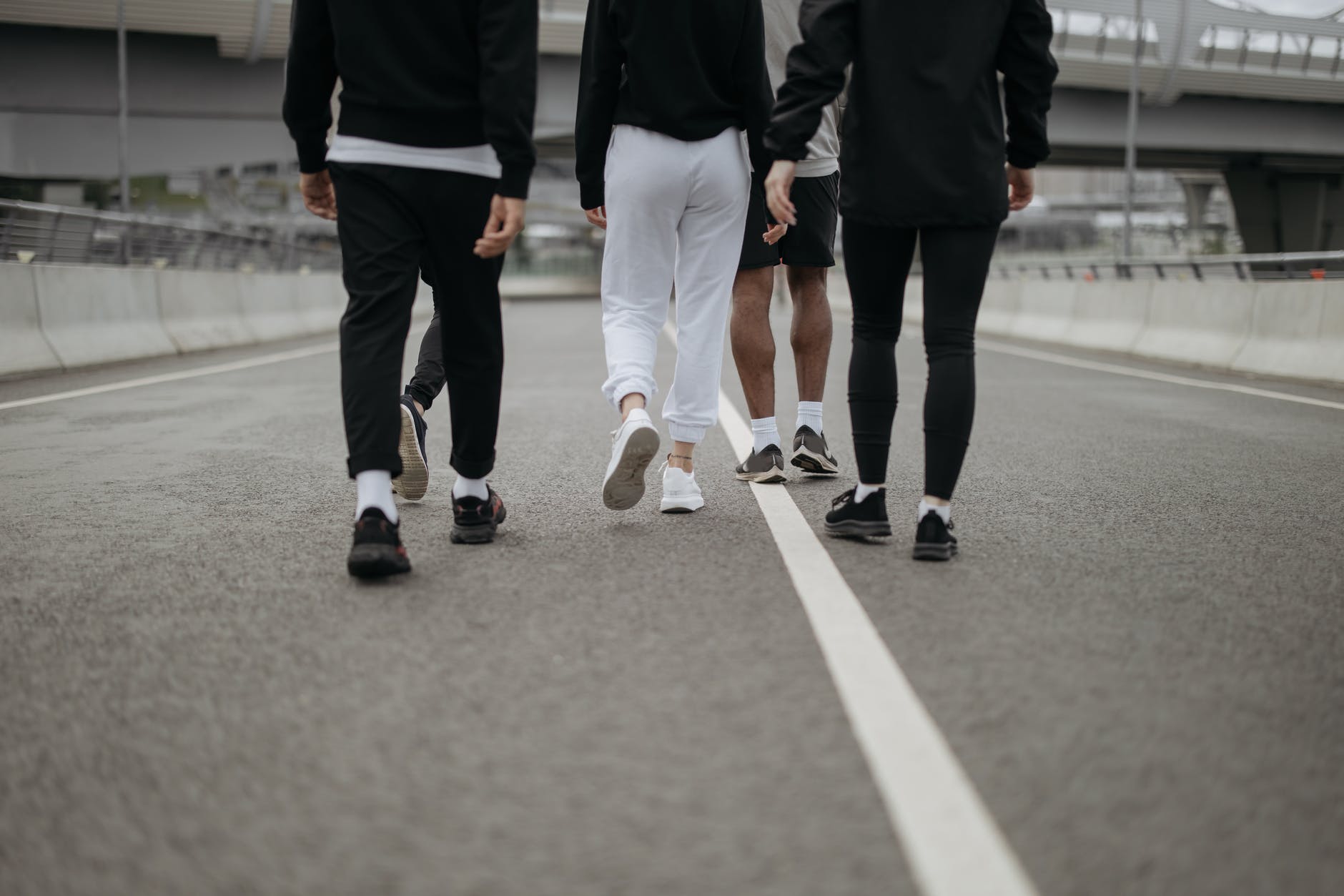 people in their activewear walking on an asphalt road