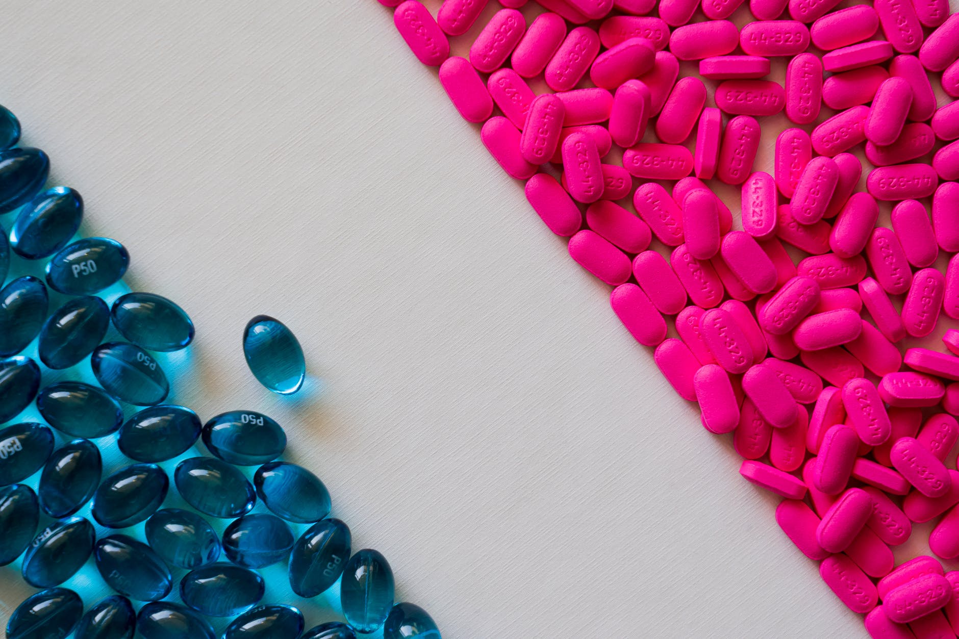pink tablets and blue capsules in close up view