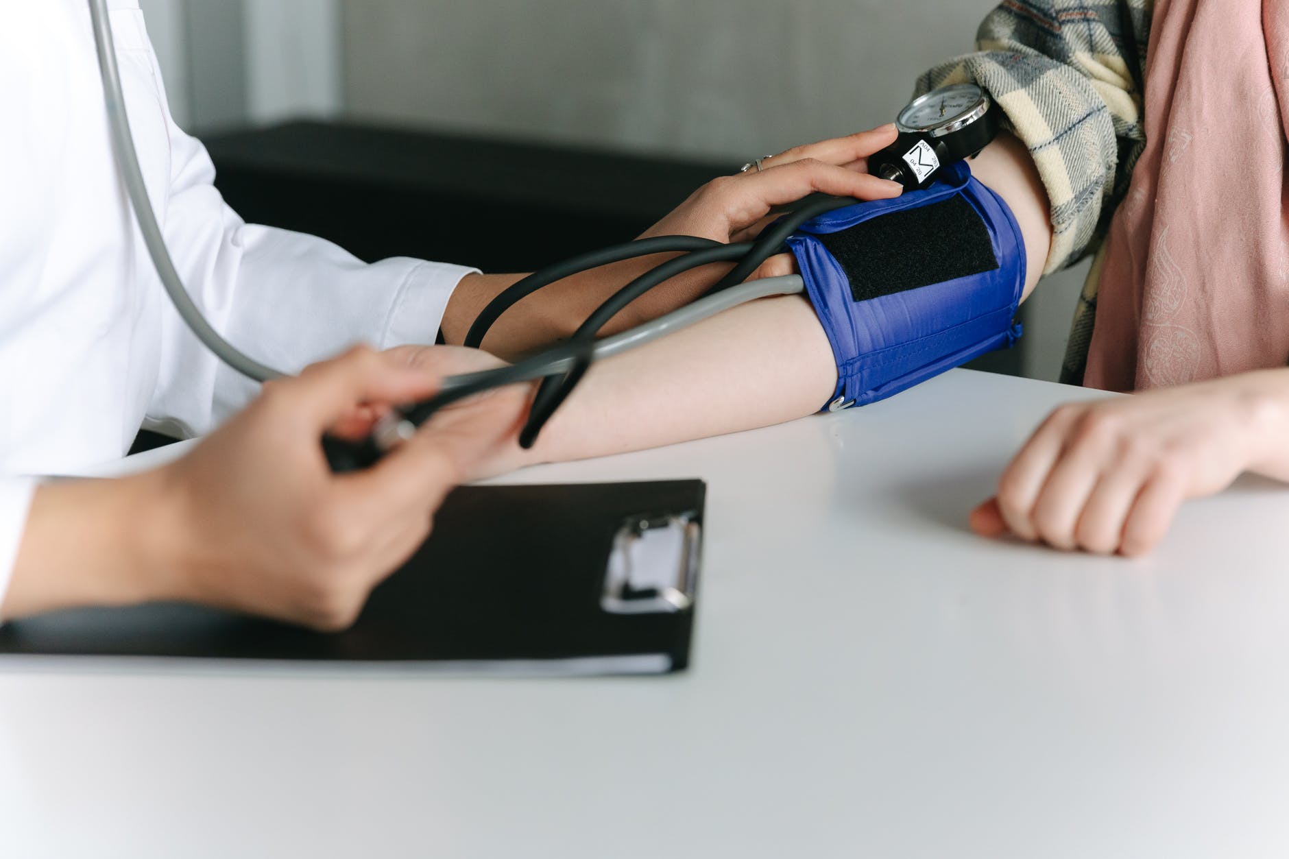 a healthcare worker measuring a patient s blood pressure using a sphygmomanometer