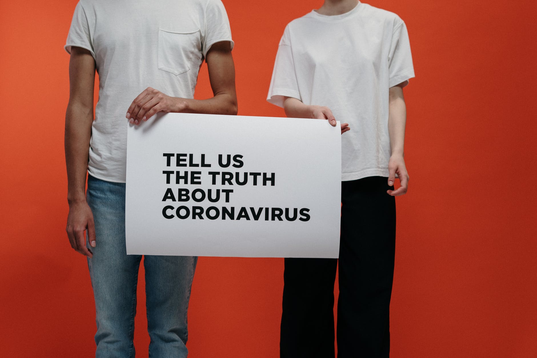 people holding a poster asking about facts on coronavirus