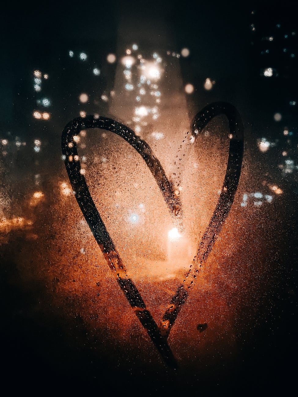 heart drawn on glass of wet window
