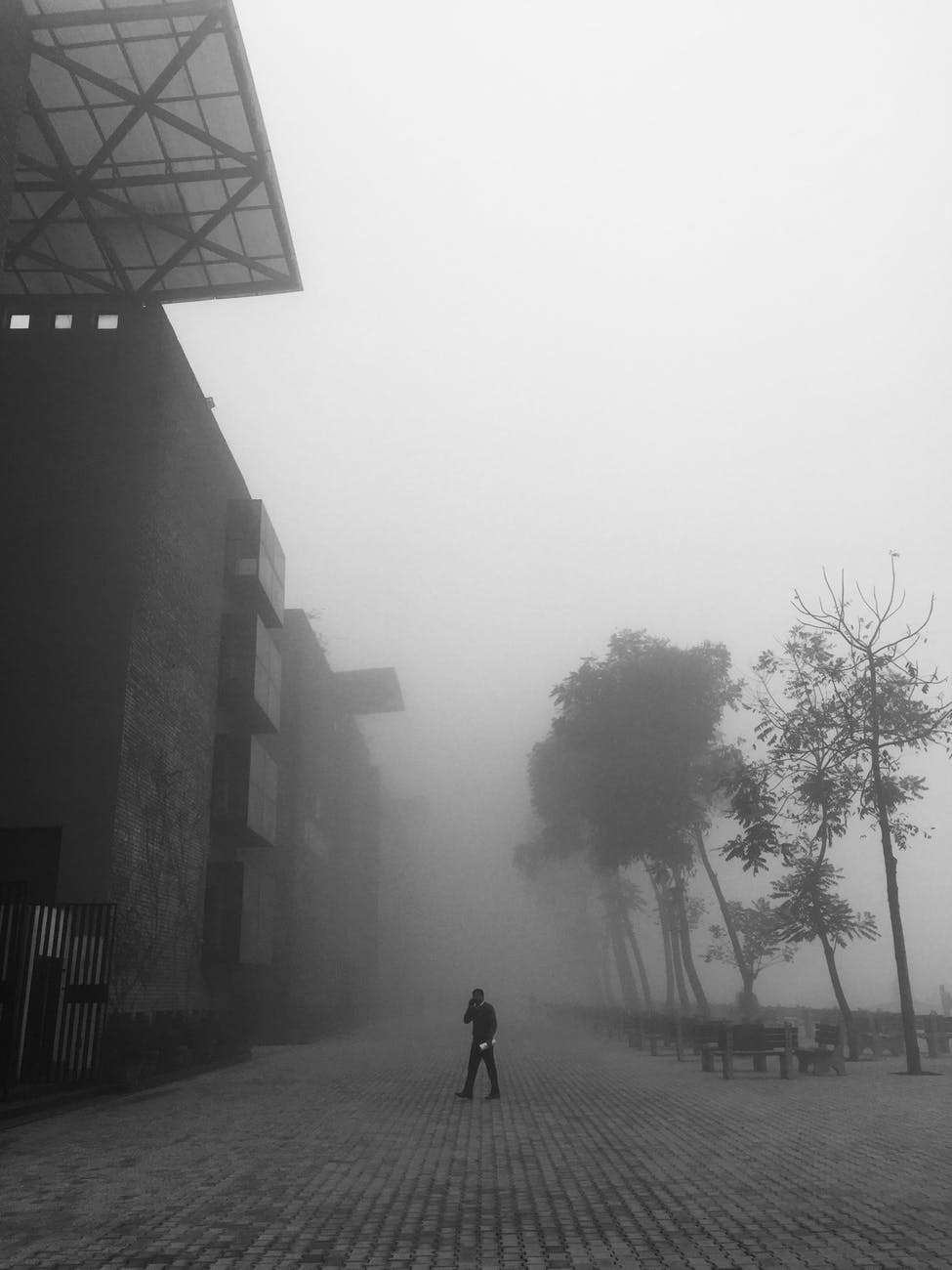 person walking outside industrial building in haze