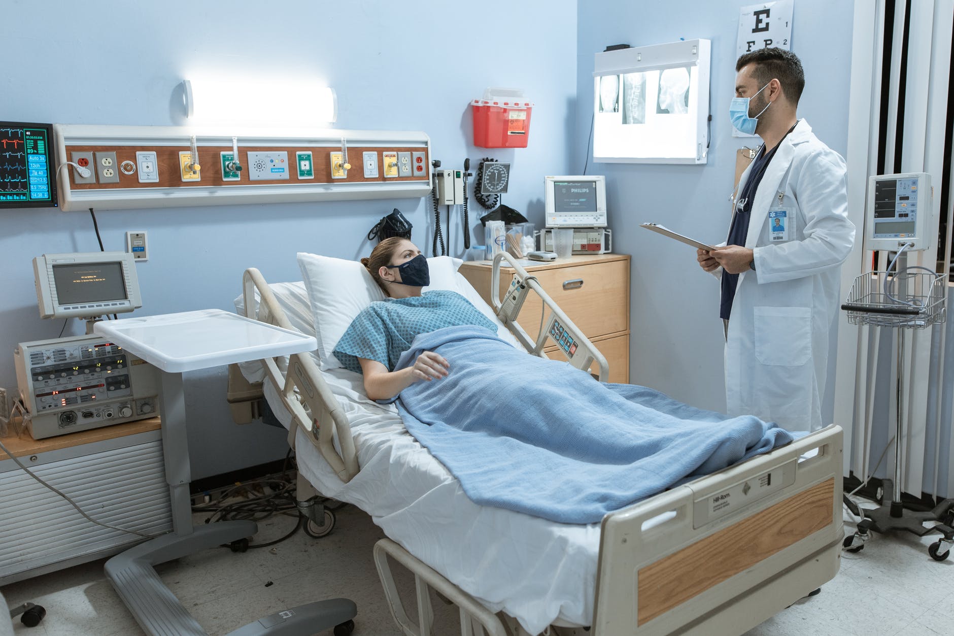 doctor talking to a patient lying down on a hospital bed
