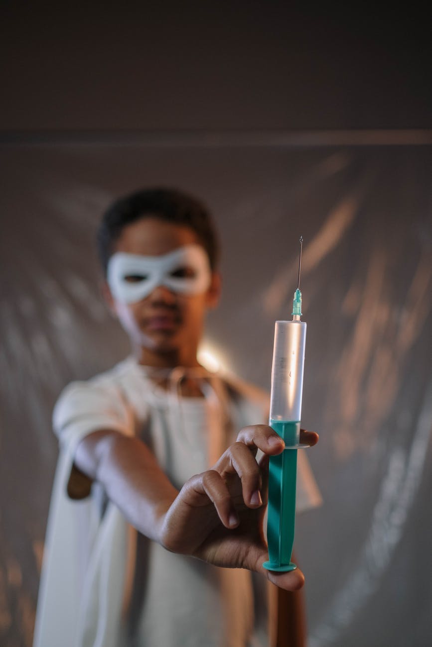 a boy wearing a mask holding a syringe